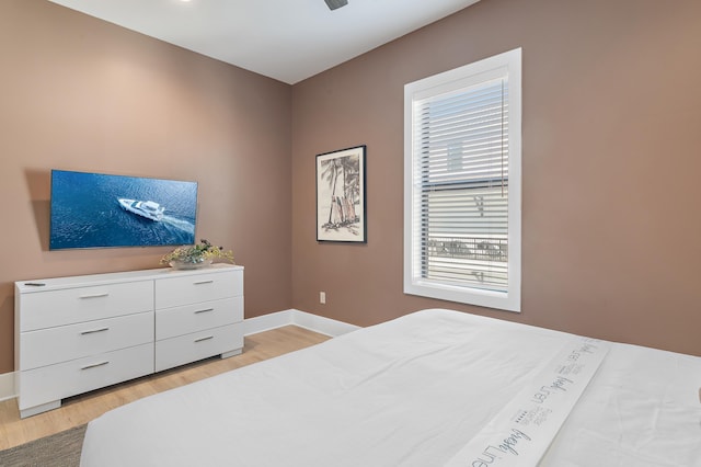 bedroom with ceiling fan, baseboards, and light wood-style flooring