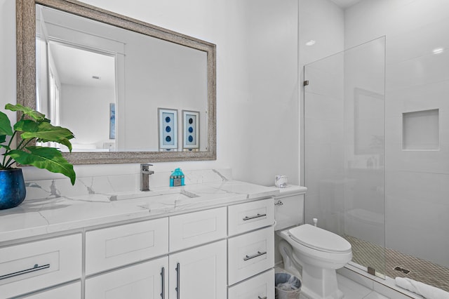 bathroom featuring vanity, a shower stall, and toilet