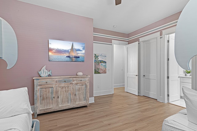 bedroom featuring a ceiling fan, light wood-type flooring, and baseboards