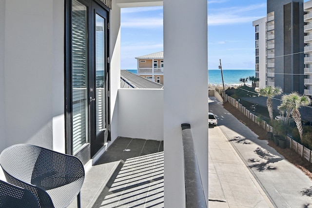 balcony featuring a beach view and a water view