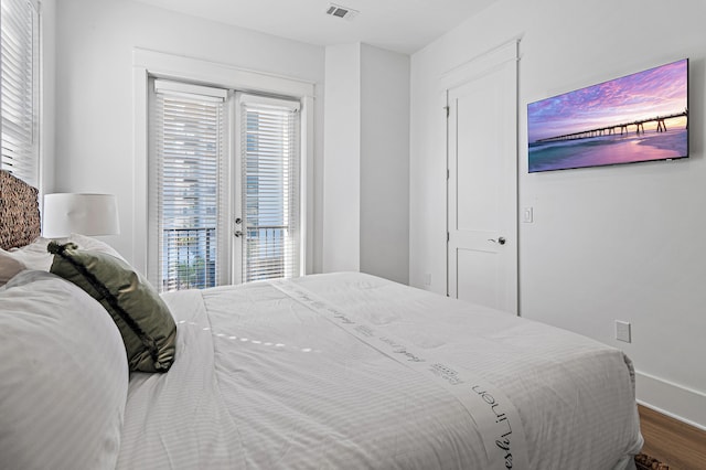 bedroom featuring access to exterior, visible vents, dark wood-type flooring, and baseboards