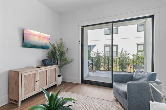 doorway to outside featuring baseboards and wood finished floors