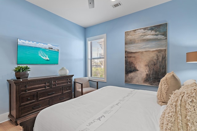 bedroom featuring visible vents, a ceiling fan, light wood-style floors, and baseboards