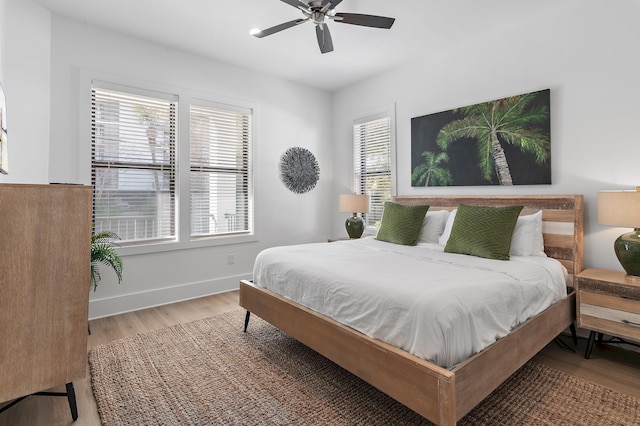 bedroom featuring a ceiling fan, baseboards, and wood finished floors