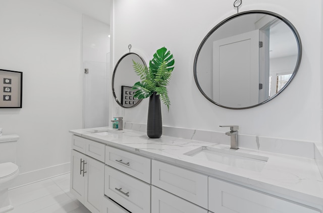 full bathroom featuring a sink, baseboards, toilet, and double vanity