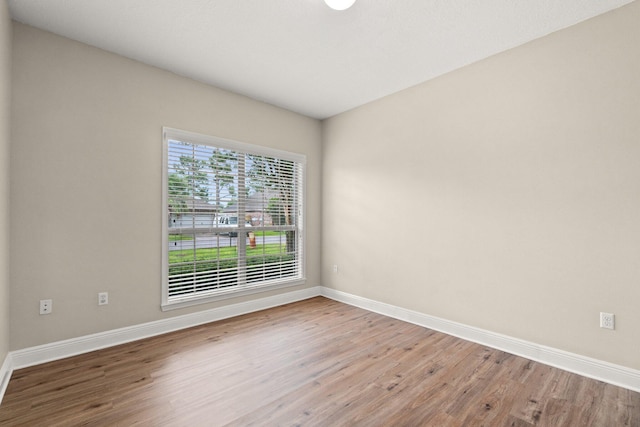 empty room featuring baseboards and wood finished floors