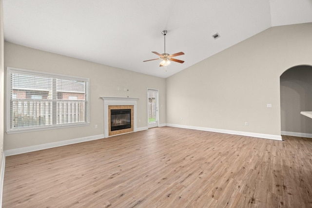 unfurnished living room featuring visible vents, a fireplace, ceiling fan, vaulted ceiling, and light wood-style floors