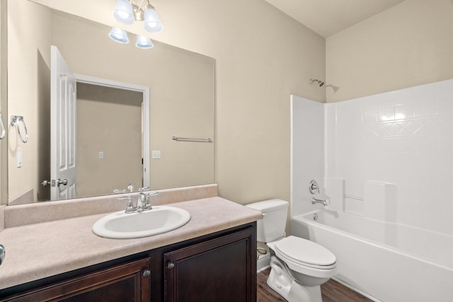 full bath featuring shower / bath combination, toilet, wood finished floors, and vanity