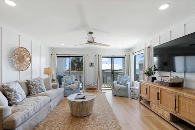 living area with a ceiling fan, recessed lighting, light wood-type flooring, and ornamental molding