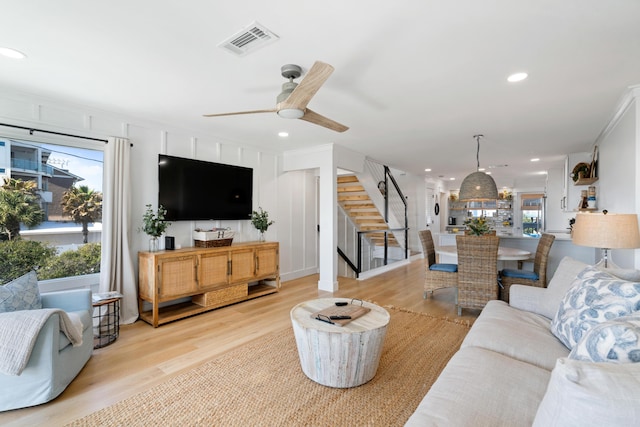 living room with stairway, recessed lighting, visible vents, and light wood finished floors