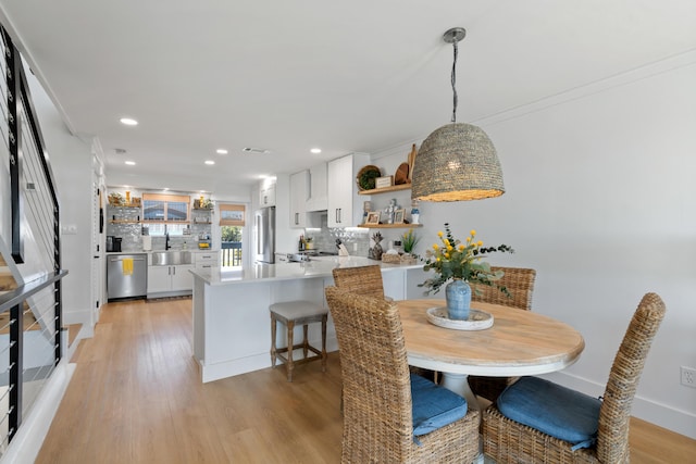 dining area with recessed lighting, light wood-type flooring, and baseboards