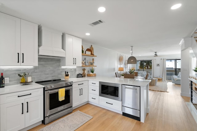 kitchen with visible vents, open floor plan, light countertops, appliances with stainless steel finishes, and a peninsula