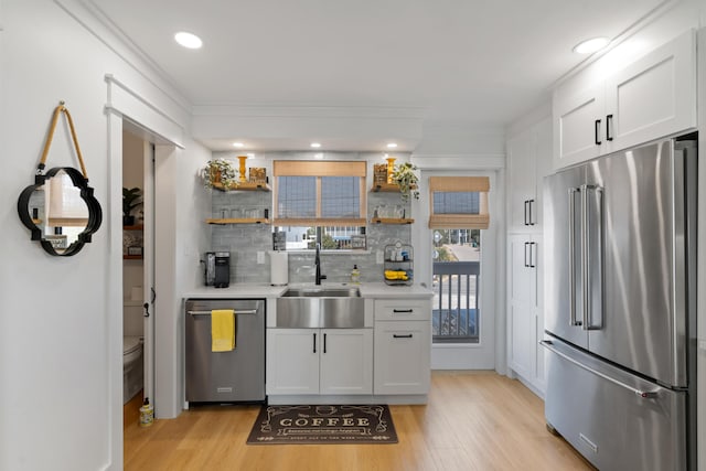 kitchen featuring open shelves, a sink, stainless steel appliances, light countertops, and white cabinetry