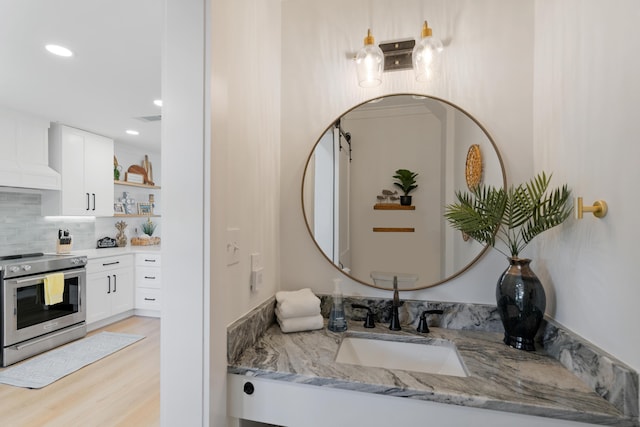 bathroom with visible vents, decorative backsplash, recessed lighting, wood finished floors, and vanity