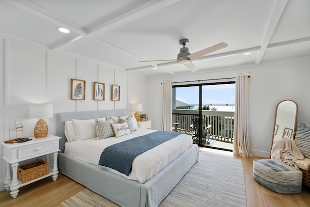 bedroom with beamed ceiling, coffered ceiling, wood finished floors, and access to outside