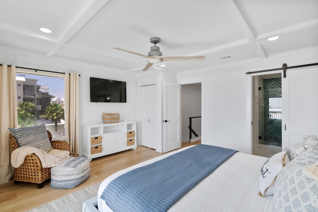 bedroom featuring visible vents, beamed ceiling, a barn door, light wood-style floors, and coffered ceiling