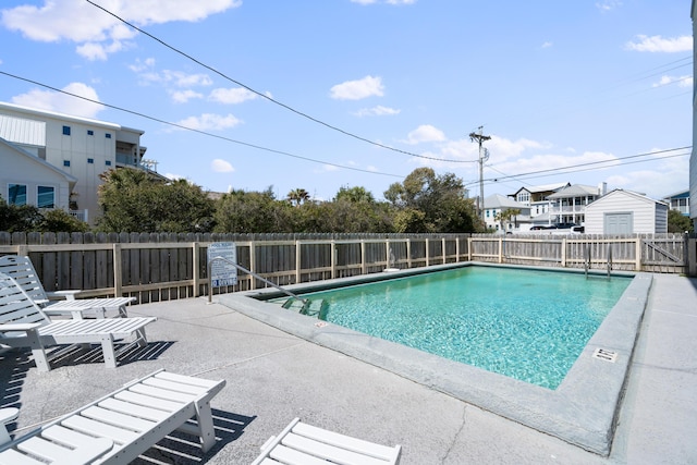 pool with a patio area and a fenced backyard