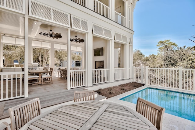 exterior space featuring a fenced in pool, ceiling fan, fence, a wooden deck, and outdoor dining area