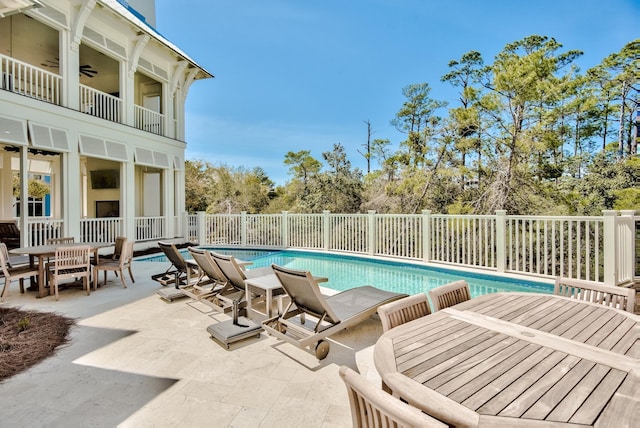 view of swimming pool featuring a patio area, outdoor dining space, a fenced in pool, and ceiling fan