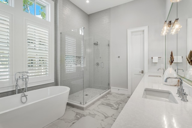 full bathroom featuring a shower stall, a soaking tub, marble finish floor, and a sink