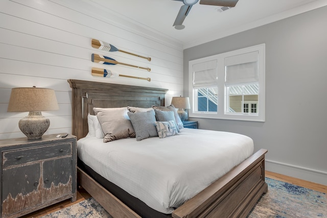 bedroom featuring ceiling fan, baseboards, wood finished floors, and ornamental molding