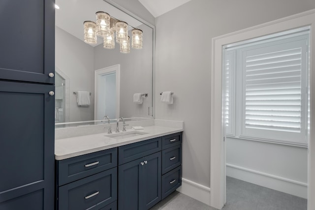 bathroom featuring baseboards, vanity, and vaulted ceiling