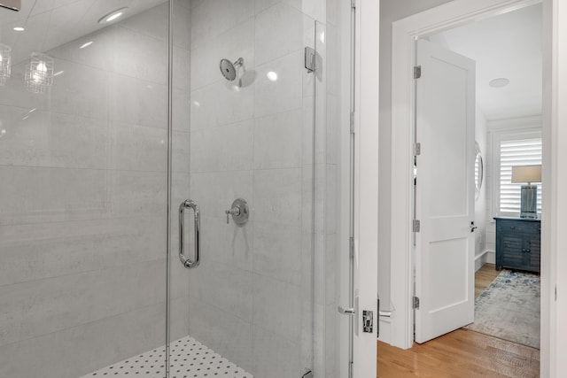 bathroom with a stall shower and wood finished floors