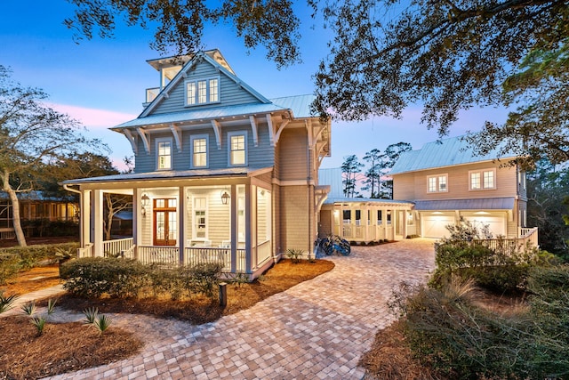 11 Dandelion Dr, Santa Rosa Beach, FL 32459 - view of front of property featuring a porch, decorative driveway, metal roof, and an attached garage