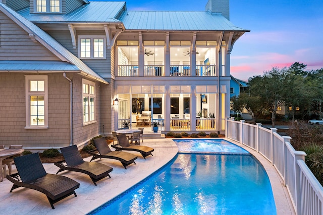 11 Dandelion Dr, Santa Rosa Beach, FL 32459 - back of house with a balcony, a patio area, metal roof, an outdoor pool, and a chimney