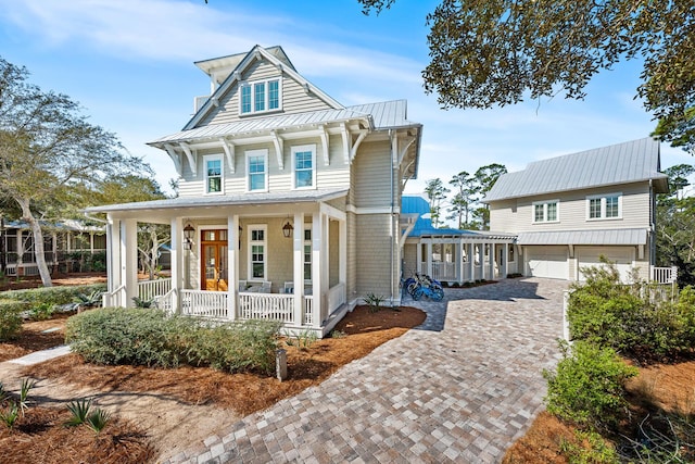 11 Dandelion Dr, Santa Rosa Beach, FL 32459 - view of front of home with covered porch, a garage, decorative driveway, a standing seam roof, and metal roof