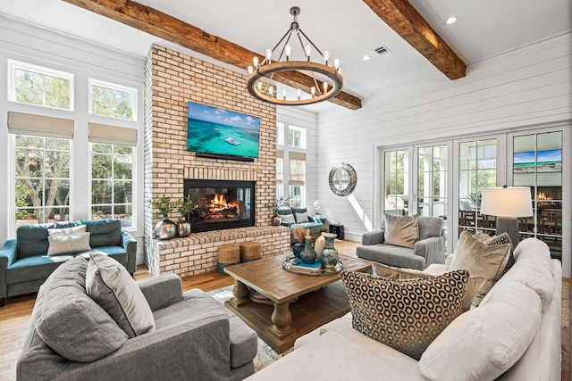 11 Dandelion Dr, Santa Rosa Beach, FL 32459 - living area featuring a brick fireplace, wood finished floors, beamed ceiling, wooden walls, and a chandelier