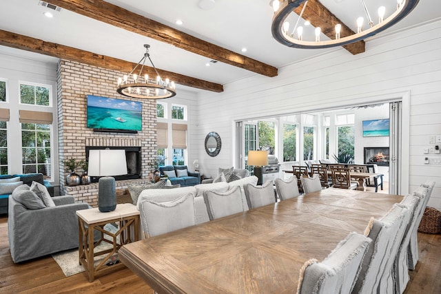 11 Dandelion Dr, Santa Rosa Beach, FL 32459 - dining room with a chandelier, a fireplace, wood walls, wood finished floors, and beam ceiling