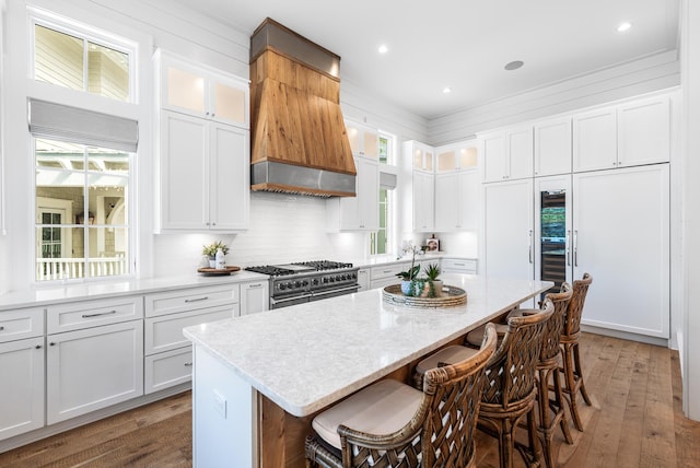 11 Dandelion Dr, Santa Rosa Beach, FL 32459 - kitchen with range with two ovens, custom range hood, light wood finished floors, a kitchen island, and recessed lighting