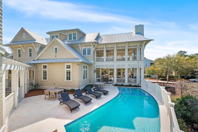 11 Dandelion Dr, Santa Rosa Beach, FL 32459 - rear view of house with a balcony, a chimney, metal roof, and a patio area