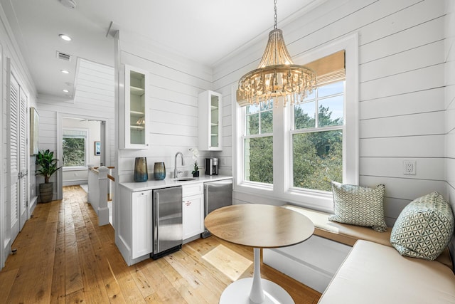 11 Dandelion Dr, Santa Rosa Beach, FL 32459 - kitchen with a sink, light countertops, white cabinetry, light wood-style flooring, and glass insert cabinets