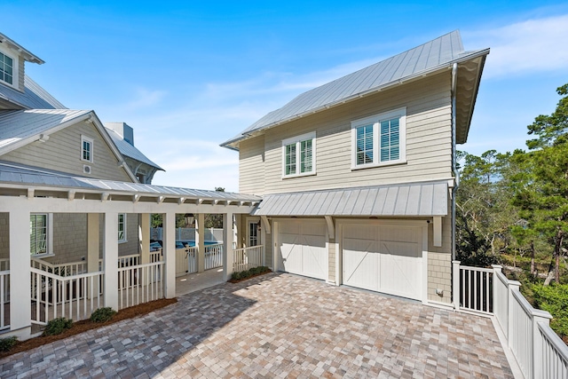 11 Dandelion Dr, Santa Rosa Beach, FL 32459 - view of front of home featuring a standing seam roof, metal roof, an attached garage, fence, and decorative driveway