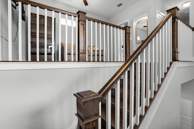 stairway featuring a ceiling fan and visible vents