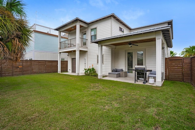 rear view of property with a patio, a fenced backyard, a yard, a balcony, and ceiling fan