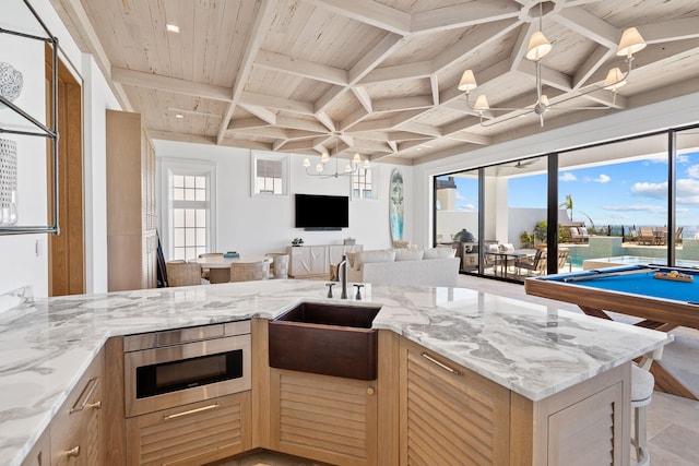 kitchen featuring built in microwave, open floor plan, wood ceiling, coffered ceiling, and a sink