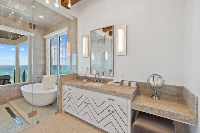 full bath with tile patterned floors, a stall shower, vanity, and a freestanding tub