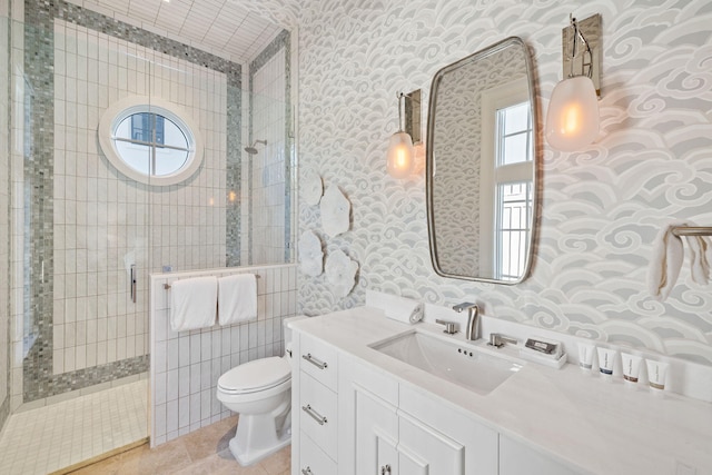 full bathroom with tiled shower, toilet, vanity, and wallpapered walls