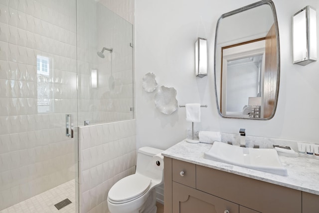 bathroom featuring toilet, a stall shower, and vanity