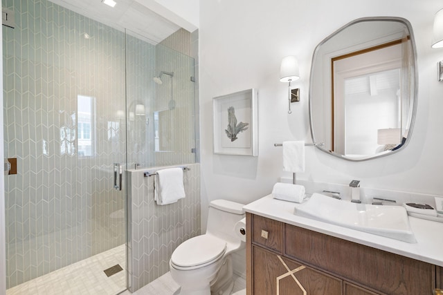 bathroom with vanity, a shower stall, and toilet