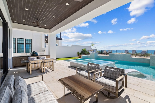 view of patio / terrace featuring an in ground hot tub and an outdoor pool