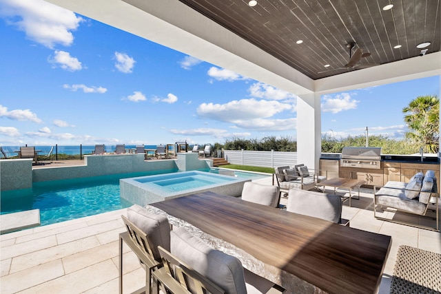 view of pool featuring ceiling fan, fence, an outdoor kitchen, a grill, and a patio