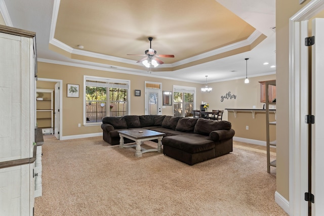 carpeted living area featuring a tray ceiling, baseboards, and a healthy amount of sunlight