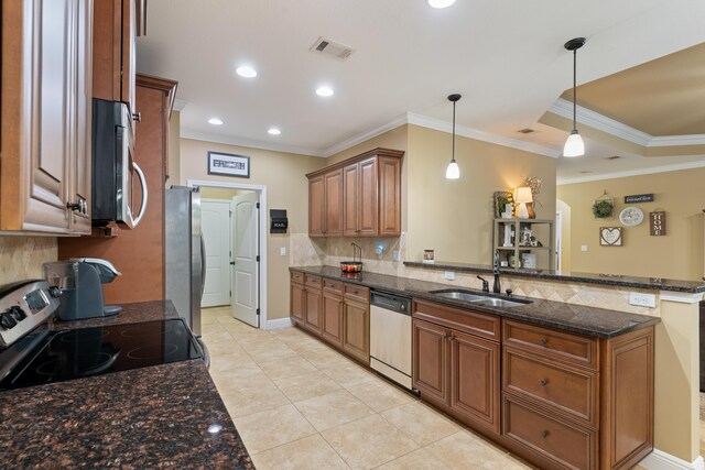 kitchen with brown cabinets, a peninsula, stainless steel appliances, and a sink