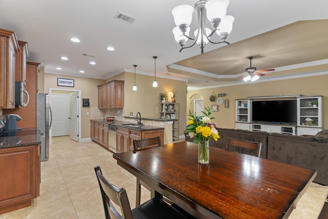 dining room featuring arched walkways, visible vents, ceiling fan with notable chandelier, and crown molding