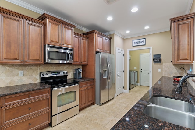 kitchen with crown molding, brown cabinets, light tile patterned flooring, stainless steel appliances, and a sink