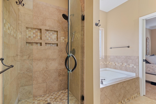 ensuite bathroom with connected bathroom, a bath, and a shower stall